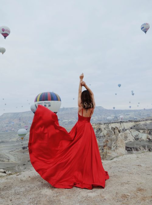 Woman in Cappadocia with hot air balloons in background